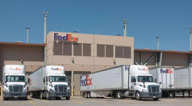 FedEx delivery trucks sit outside the company's warehouse facility at SkyHarbor Airport in Phoenix.