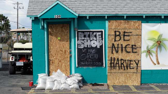 A sign reading "Be Nice Harvey" was left behind on a boarded up business, Thursday, Aug. 24, 2017, in Port Aransas, Texas. Port Aransas is under a mandatory evacuation for Hurricane Harvey.