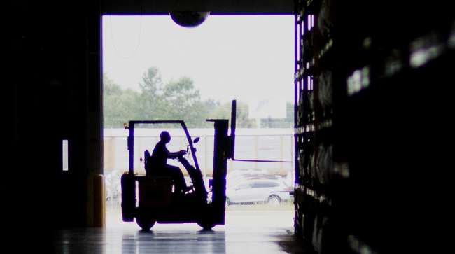 The silhouette of an employee is seen operating a forklift at the Subaru of Indiana Automotive Inc. assembly plant in Lafayette, Ind.